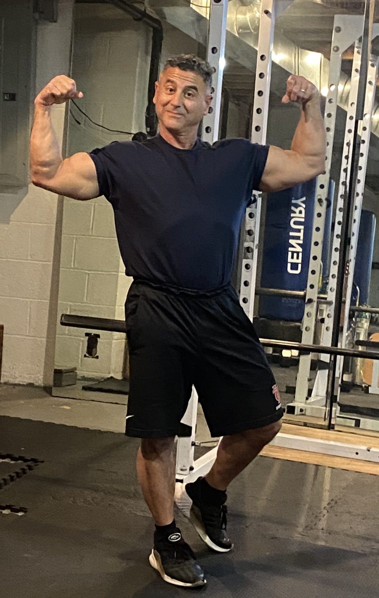 Dr. Robert Fortino, Strong, Not Skinny Dr. Robert Fortino flexing a double-biceps pose in front of a power rack, Philadelphia weight loss doctor
